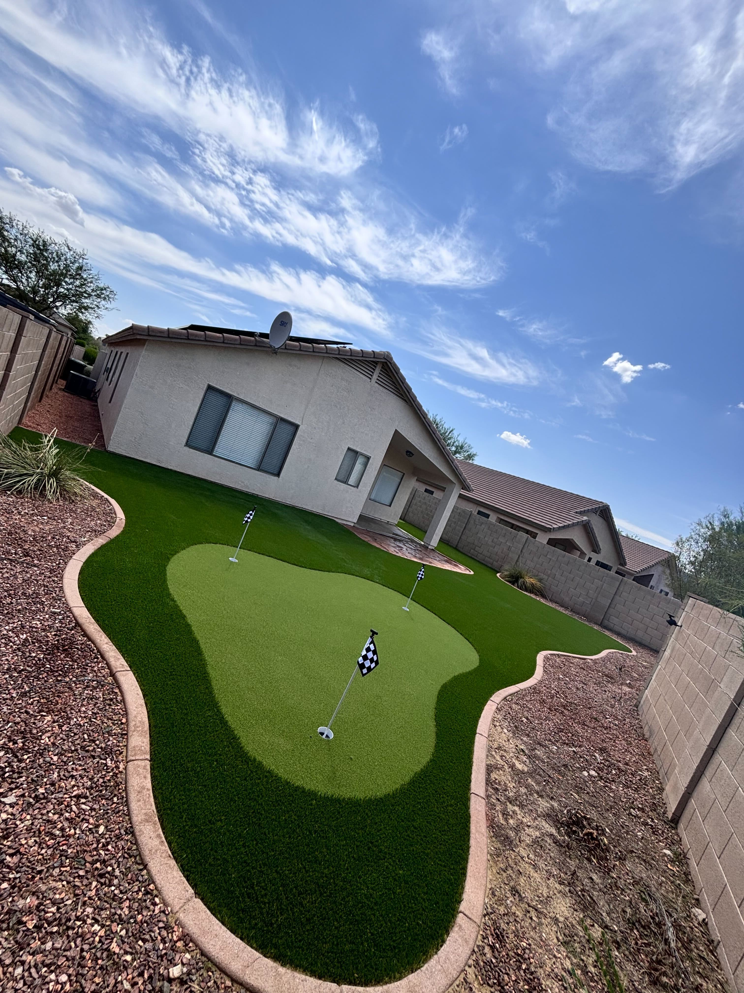 Backyard after artificial turf installation — lush green lawn