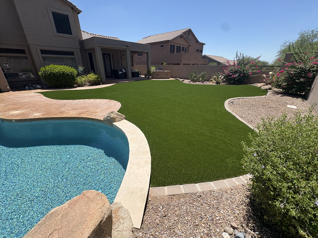 Artificial grass installed to a clean paver edge beside a pool in Arizona