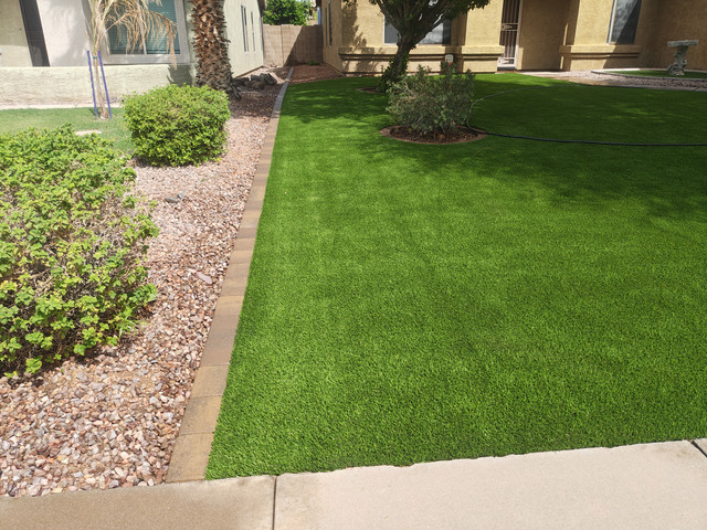 Finished artificial turf alongside a curved border, gravel planting beds, and established landscaping