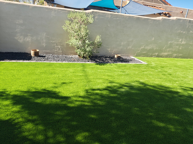 Shade sail casting shade over an artificial turf lawn in an Arizona backyard