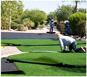 Workers installing the green grass on the lawn